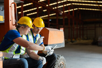 Two man warehouse workers in safety uniform using digital tablet inspect product iron metal goods...