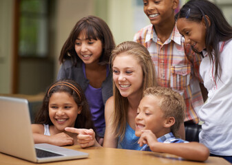 Children, students and laptop in classroom for education, learning and video streaming with group project. Happy young kids and girl with leadership on computer at school for online information