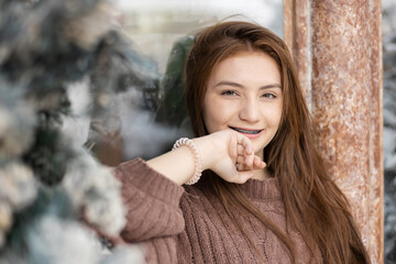 Close up portrait of face young caucasian beautiful woman blond hair smiling with braces. Happy girl in good mood smile showing teeth looking at camera.