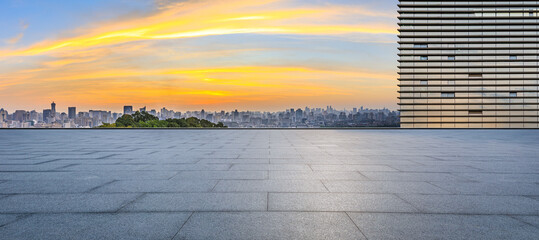 Empty square floor and glass wall with city skyline at sunrise in Hangzhou