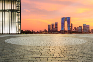 Round square floor and modern city buildings at dusk in Suzhou