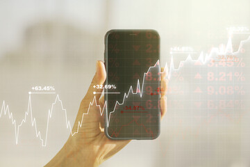 Double exposure of abstract creative financial chart and hand with cell phone on background, research and strategy concept
