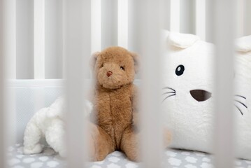 White baby's crib with stuffed animals - obrazy, fototapety, plakaty
