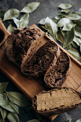 Wholemeal bread with dried cranberries and bay leaves on wooden board