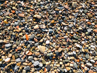 background of pile of small sea stones of various colors