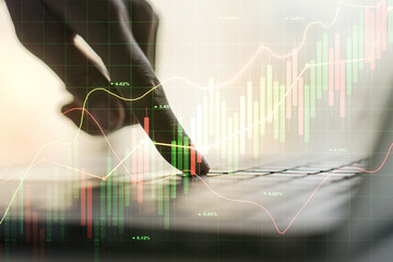 Multi exposure of abstract creative financial graph with hand typing on laptop on background, forex...
