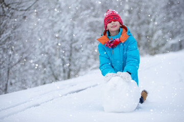 Fototapeta na wymiar Happy little boy with a big snow globe. Happy winter holidays concept.