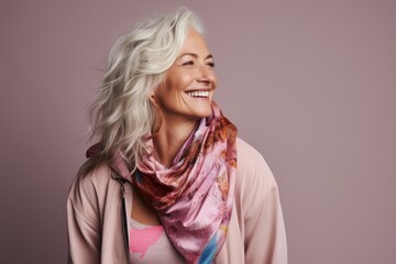 Portrait of smiling senior woman in pink blouse and scarf.