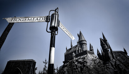 Naklejka premium Hogsmead and Hogwarts Sign pointing to the Castle at the Wizarding World of Harry Potter area in Universal Studios Hollywood - Los Angeles, California