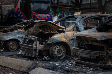 Fototapeta premium Dnepr, Ukraine – January 6: Russian drones attacked the Dnieper. Burnt and damaged cars in the Dnieper. Utility services clean up the aftermath of the attack on the city.