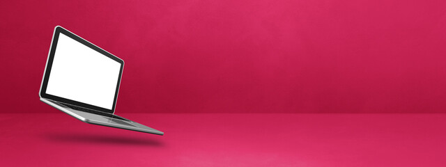 Floating computer laptop isolated on pink. Horizontal banner background