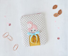 Lovely handmade zipper pouch with cute doll applique over white	