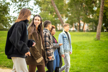 Beautiful, happy girl walks with friends in fall park