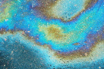 Colored oil stains close up, the color of the gasoline stain on the pavement road as a texture or background