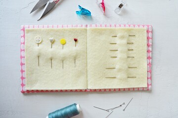 Simple handmade needle book, pins, thread clipper and clips on white