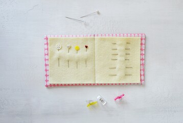 Simple handmade needle book, pins and clips on white