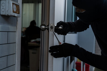 Burglar forcing open a house door