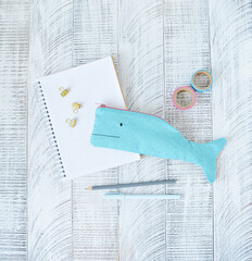 Blue whale pencil case, notes, pens, golden clips and washi tapes on desk
