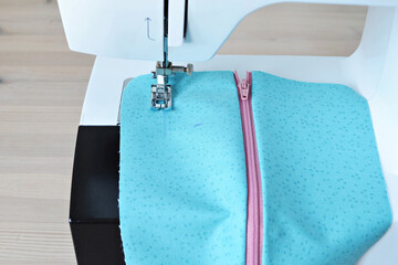 Working process: fabric and sewing machine on wooden table