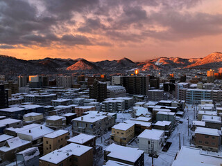 2024年１月札幌市内の朝焼けの雪景色の町並み　