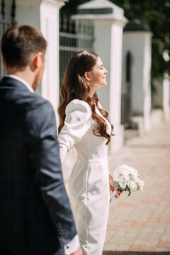 The image is a romantic scene of a man and woman kissing. The woman is wearing a wedding dress and the man is in a