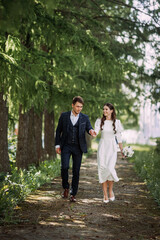 A man and a woman walking down a path in a forest 5137.