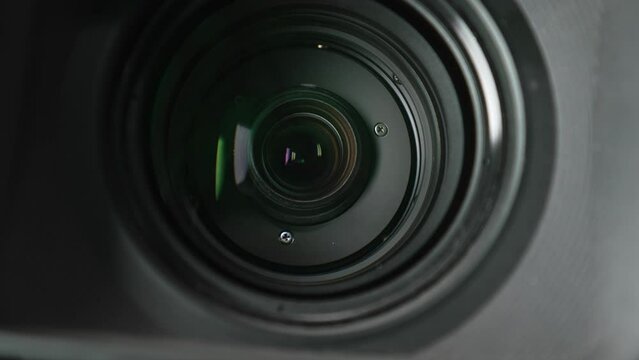 Macro video of the working lens of a camcorder with inner rings and lenses inside. Close-up shooting zooming with the lens of a professional video camera while shooting in the studio.