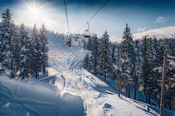 Sunny winter view from the chairlift of snowy hills on Dragobrat ski resort. Picturesque mowning...