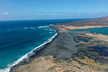 Drone panoramic view of Playa del Janubio in Lanzarote with the volcanic landscape in the background  with turquoise sea and big waves. Nature and tourism.  Canary Islands, Spain.