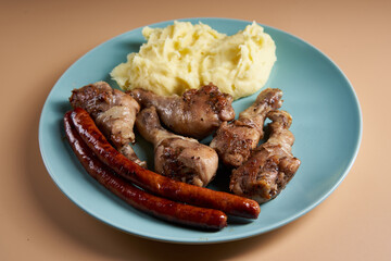 Grilled chicken legs and sausage sticks with mashed poatatoes