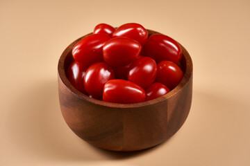 Cherry tomatoes in a bowl isolated on beige