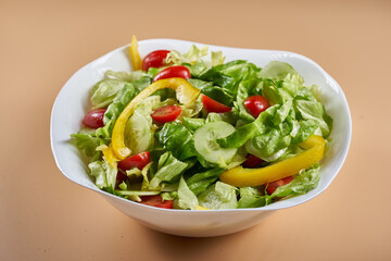 Salad in a bowl on beige background, isolated