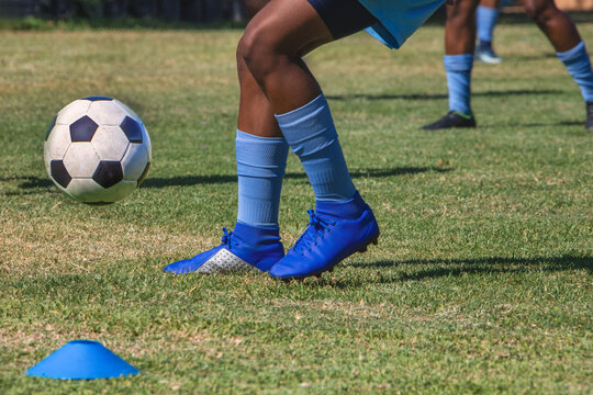 soccer college african american players in uniform kicking the ball on the football field
