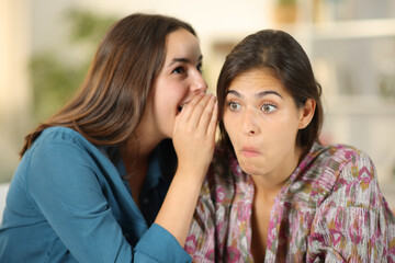 Gossip woman telling secret to a perplexed friend