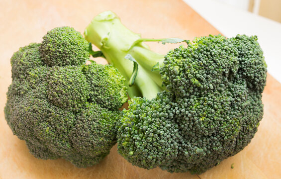Healthy broccoli and florets on wooden board