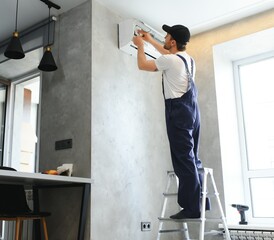 Happy Male Technician Repairing Air Conditioner.