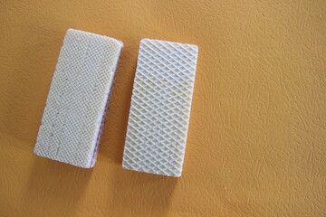 Obraz premium Two Vanilla Wafers on Orange Background