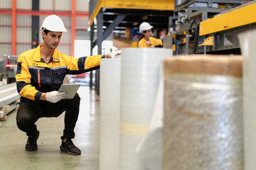 Latino industrial engineer wears safety uniform work in heavy steel engineering factory. Hispanic worker in white hard hat checking product materials equipment in metalwork manufacturing facility