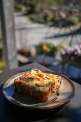 カフェのテラス席で食べるピザトースト