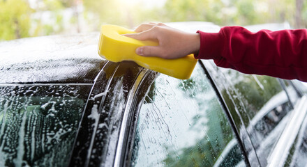 Hand hold sponge clean the car - obrazy, fototapety, plakaty