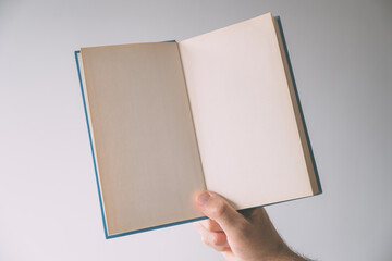 Hardcover book mockup blank pages, male hand holding printed publication