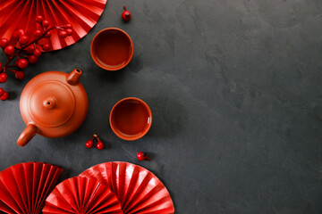 Chinese new year festival decorations with classic clay teapot and red Chinese folded fans.