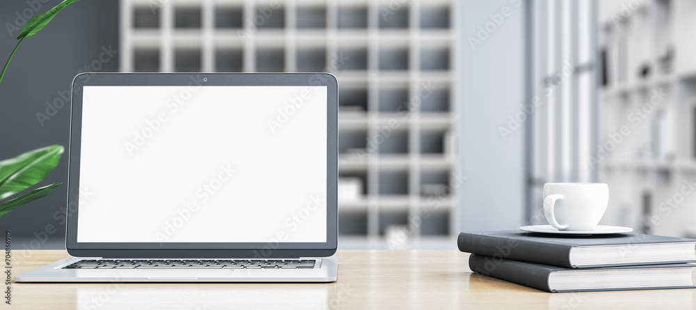 Poster modern wide designer office desktop with empty white mock up laptop screen, coffee cup on stacked bo