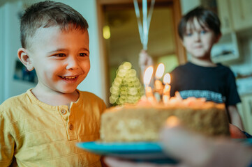 Excited boy looking at birthday cake