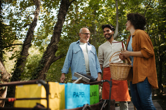 Group of volunteers taking part in community cleanup at park with waste separation bags