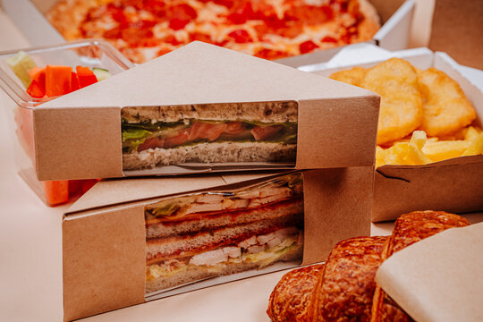 Packed sandwiches with croissant against beige background
