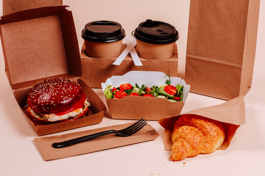 Fast foods with burger and coffee cups against beige background