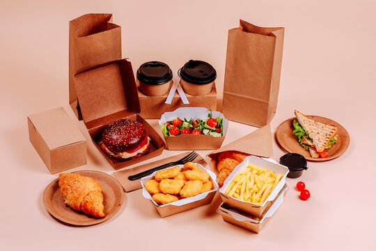 Fast foods with salad and coffee cups against beige background