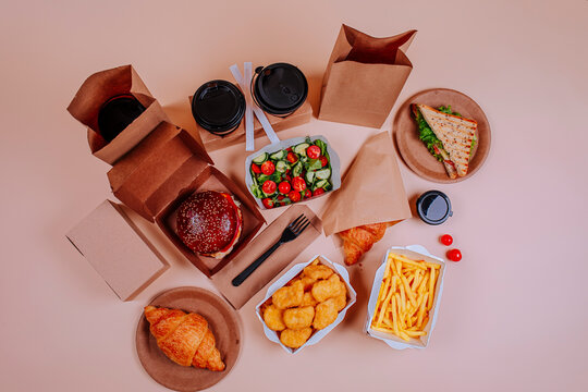 Salad and fast foods with coffee cups against beige background