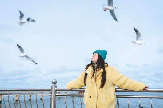 Woman with eyes closed near railing